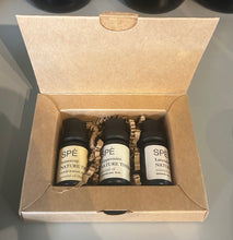 Three Spe essential oil bottles in a cardboard box on a gray surface
