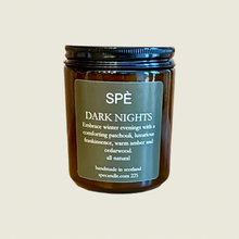 Candle jar labeled 'Dark Nights' by Speé on a beige background
