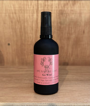 A black bottle with pink label. An all natural room spray, scented like a field of wildflowers.